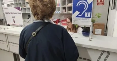 mujer mayor con discapacidad auditiva cerca del bucle magnético de la oficina de Avanza