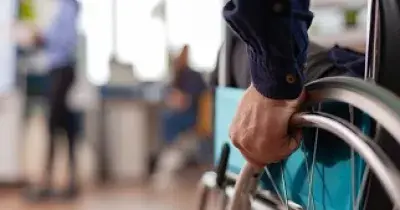 Una persona en silla de ruedas entrando en una sala (Fuente: Servimedia)