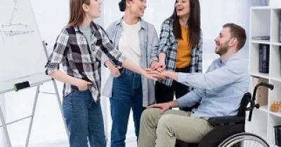 Un grupo de jóvenes con una persona en silla de ruedas, mostrando señales de compañerismo (Fuente: Servimedia)