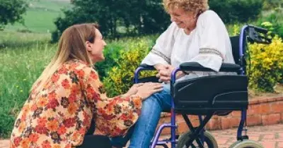 Una mujer en silla de ruedas, acompañada de otra (Fuente: Cermi)