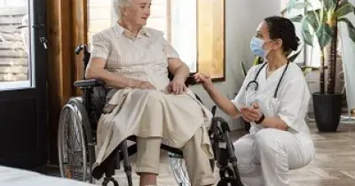 Una doctora hablando con una paciente en silla de ruedas (Fuente: Servimedia)