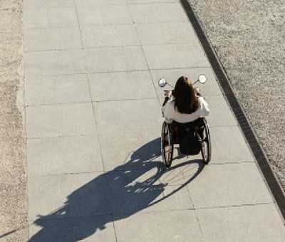 Una persona en silla de ruedas paseando por una calle (Fuente: Servimedia)