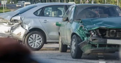 colisión de un vehículo verde con otro vehículo gris
