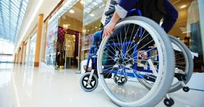 Una persona en silla de ruedas paseando por un Centro Comercial (Fuente: Servimedia)