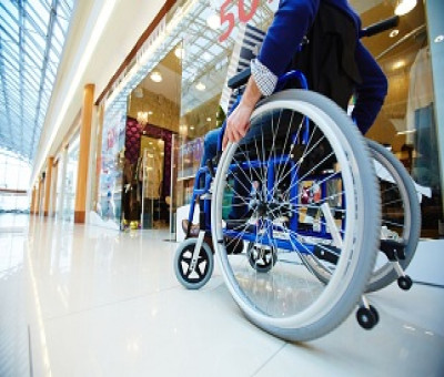 Una persona en silla de ruedas paseando por un Centro Comercial (Fuente: Servimedia)