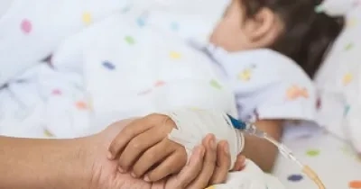 Una niña en el hospital a la que le sostienen la mano vendada (Fuente: Servimedia)