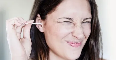 Una persona limpiándose el oído con un bastoncillo (Fuente: Oticon)