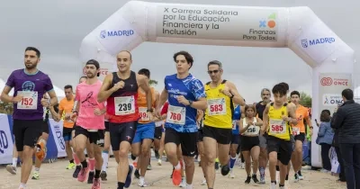Salida de la X Carrera Solidaria por la Educación Financiera y la Inclusión en el Parque Forestal de Valdebebas (Madrid), con decenas de corredores atravesando el arco de meta de una prueba organizada por ASNEF y Fundación ONCE.