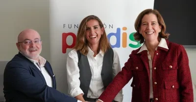 Tres personas dándose la mano frente la cámara