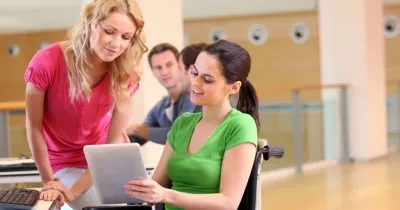 Dos mujeres trabajando, una de ellas con silla de ruedas