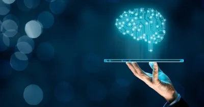 Ilustración de unja mano sosteniendo una tablet, de la que sale un cerebro realizado con puntos simulando la inteligencia artificial