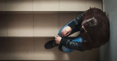 mujer triste sentada en las escaleras