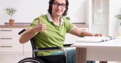 Joven estudiante con discapacidad con el libro en el escritorio