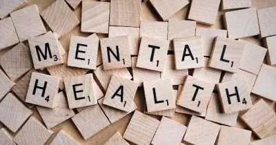 un dibujo de la salud mental con piezas de puzle,  que cada pieza contiene una letra