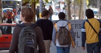 Foto de estudiantes de espaldas, de camino a la Universidad