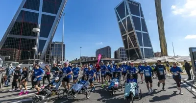 Participantes de la maratón en plena carrera con las Torres de Madrid de fondo