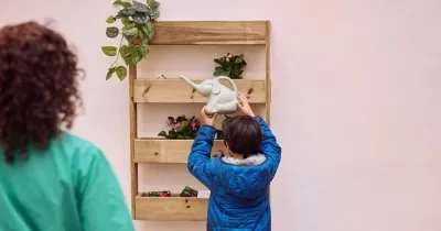 Imagen de un niñp intentando colgar un objeto en una estantería