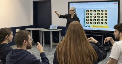 Una profesora enseñando lengua de signos a unos alumnos