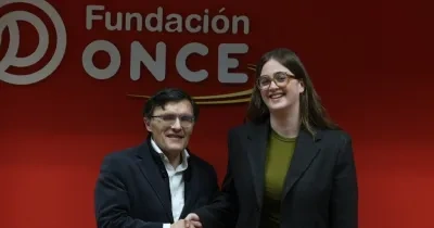 Foto de firma entre Alberto Durán y Andrea González, delante del logo de Fundación ONCE