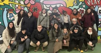 Los quince alumnos posando para una foto delante de un mural