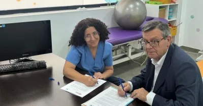 Acto de firma del acuerdo de donación entre Donoso y la jefa de rehabilitación del centro.