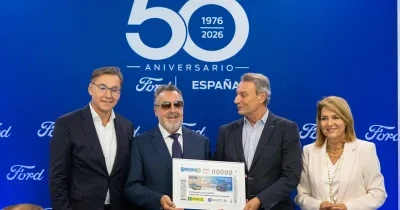 Representantes de Ford España, el Grupo Social ONCE y la Generalitat Valenciana posan durante la presentación del cupón conmemorativo del 50º aniversario de la planta de Ford en Almussafes. En el acto se muestra una reproducción ampliada del cupón dedicado a la inclusión laboral de las personas con discapacidad, con el logotipo del aniversario sobre un fondo azul corporativo de Ford.