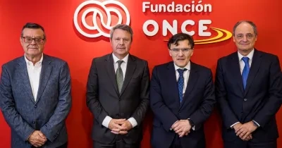 Los 4 representantes de la Fundacion ONCE posando delante del logo de la entidad 