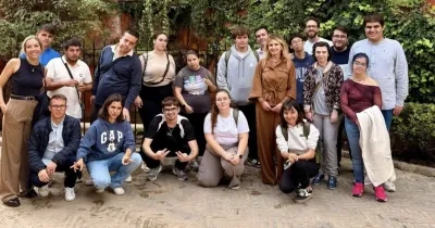 Los 15 alumnos posando en el jardín del campus para una foto grupal