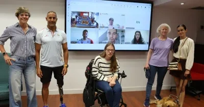 Acto oficial de la primera convocatoria de la formación, aquí estan varios deportistas con discapacidad y justo detras una pizarra digital con gente en videollamada