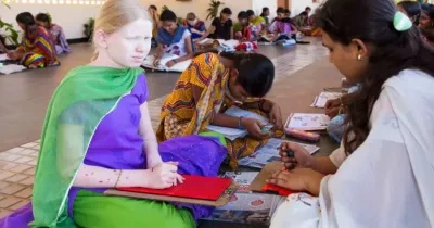 Grupo de mujeres, incluida una persona albina, realizan actividades educativas en el suelo, usando herramientas y cuadernos. Están en un espacio amplio, con luz natural y ambiente colaborativo.