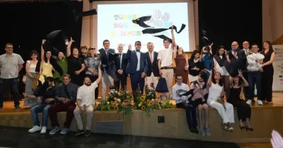 Todos los alumnos graduados posando en el escenario