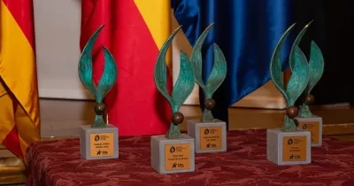 4 premios Zangalleta en la mesa, con bandera de España y Unión Europea de fondo 