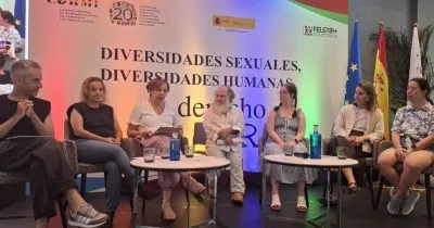 Ponentes del evento en medio del debate interactuando sentadas entre ellas