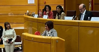 Mujer dando una conferencia en un estrado de un hemiciclo