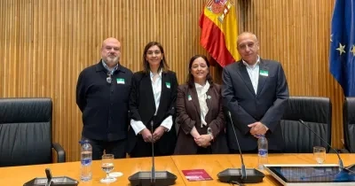 Todos los participantes de la ponencia en la sala del Congreso posando, frente a la bandera de España y de la UE