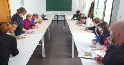 Personas realizando el taller junto a monitores voluntarios