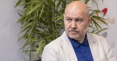 Luis Cayo hablando en el plato de Servimedia, detrás está el logo y una planta
