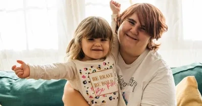 Una mare junto a su hija sentadas en el sofá