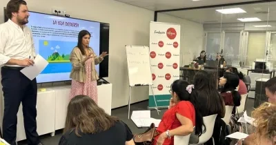 Dos profesores dando una explicación a sus alumnas, que están sentadas en sus pupitres