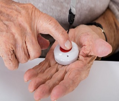 Una persona mayor con un botón rojo de teleasistencia (Fuente: CAM)