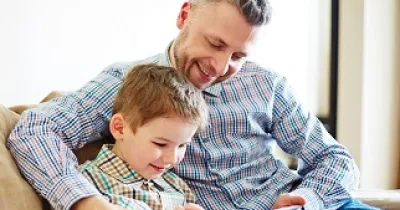 Un padre leyendo con su hijo contenidos de una tablet (Fuente: ODILO)