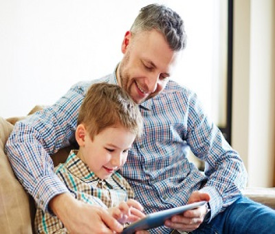 Un padre leyendo con su hijo contenidos de una tablet (Fuente: ODILO)