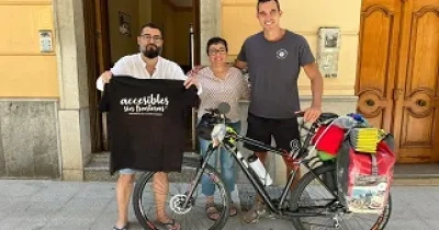 Foto de tres personas y una bici mostrando una camiseta que dice, accesibles 