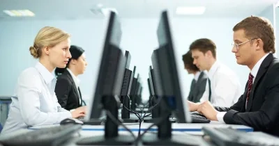 mujeres y hombres en una oficina en sus puestos de trabajo en el ordenador