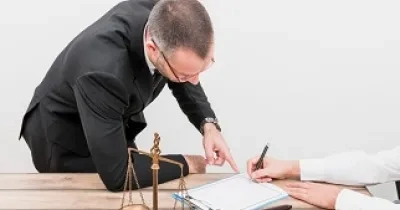 Dos personas escriben junto a símbolos que representan la justicia (Fuente: Servimedia)