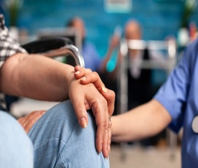 Un asistente sanitario reconforta a una persona sentada en una silla (Fuente: Servimedia)