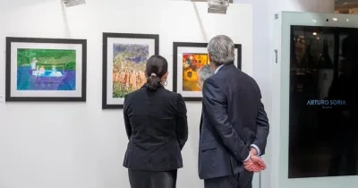 Dos personas observando un cuadro en una exposición