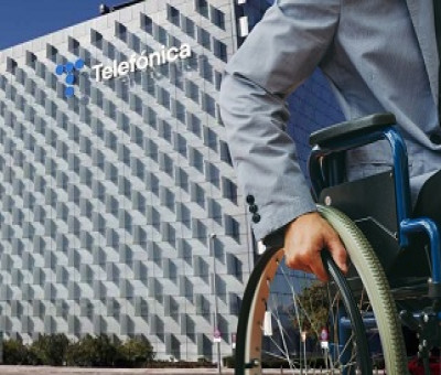 Un usuario en silla de ruedas junto a la sede de Telefónica (Fuente: UGT)