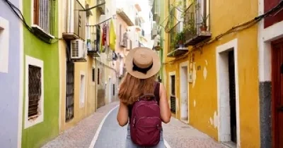 Mujer haciendo turismo por una colorida calle (Fuente: Servimedia)