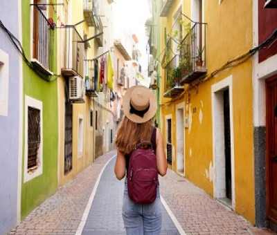 Mujer haciendo turismo por una colorida calle (Fuente: Servimedia)